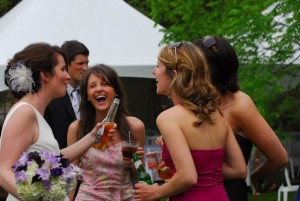 3 women laughing at a wedding
